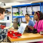 people sitting at desk in workshop and talking