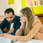 multiethnic students doing homework together in library